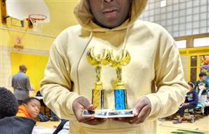 Student posing w/the trophies